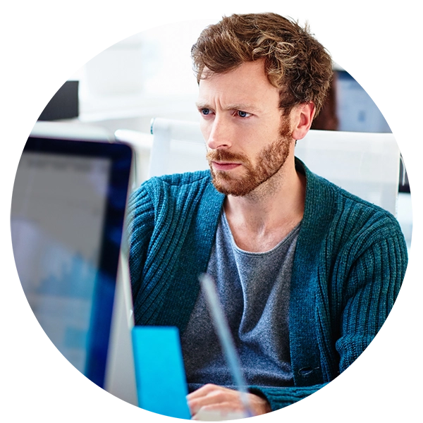 Focused employee looking at a computer screen while working at a desk